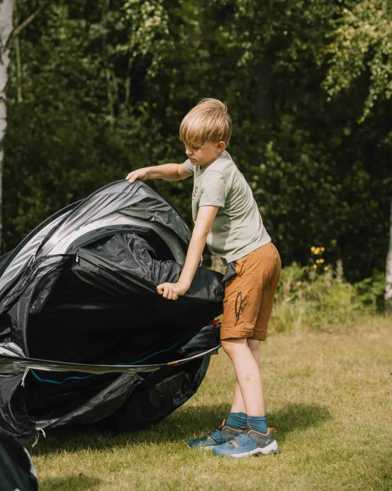 A child setting up their tent during their adventure at the Canoe Trip.