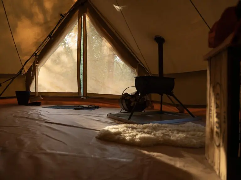 interior of a canvas tent with wood stove