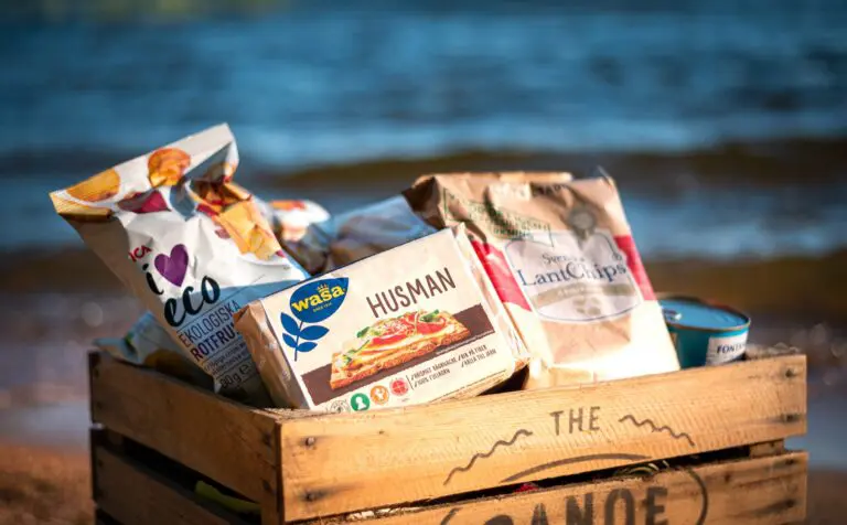 wooden crate filled with Swedish snacks on a beach
