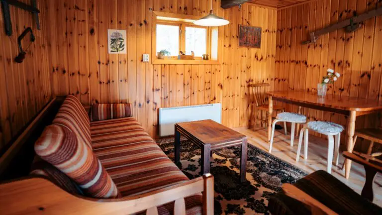 cozy lumberjack hut interior with wooden walls and striped sofa
