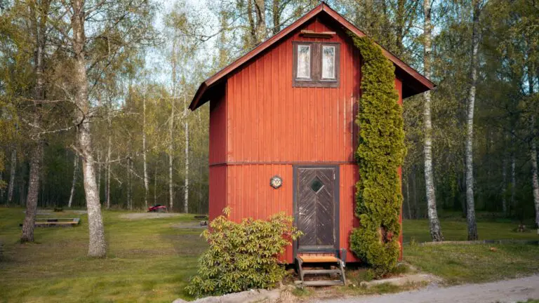 red lumberjack hut in a forest clearing