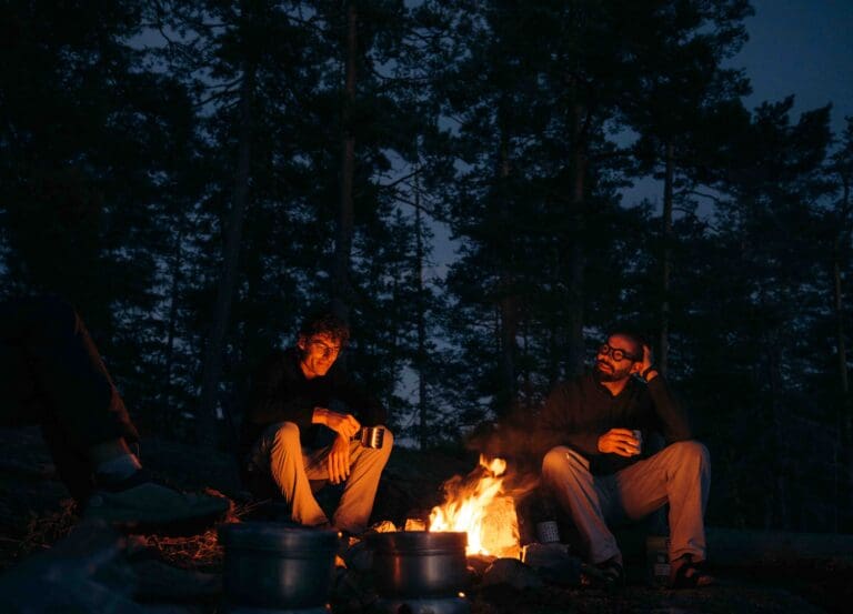 Two friends and a campfire canoeing in Sweden.